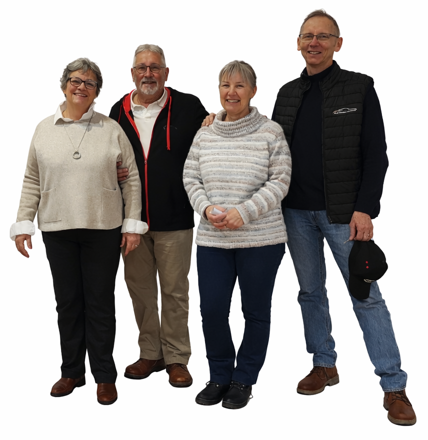 Quatre personnes âgées souriantes, habillées de façon décontractée, posent pour une photo de groupe. Deux femmes et deux hommes sont proches les uns des autres, les bras enlacés, sur un fond blanc uni.