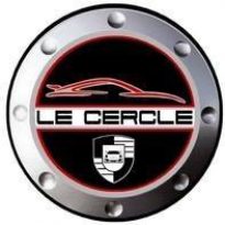 Un logo circulaire à bordure métallique, avec un contour de voiture rouge au-dessus du texte "LE CERCLE", met en évidence des trèfles indépendants, et affiche un bouclier noir et blanc avec un symbole de voiture stylisée en bas.